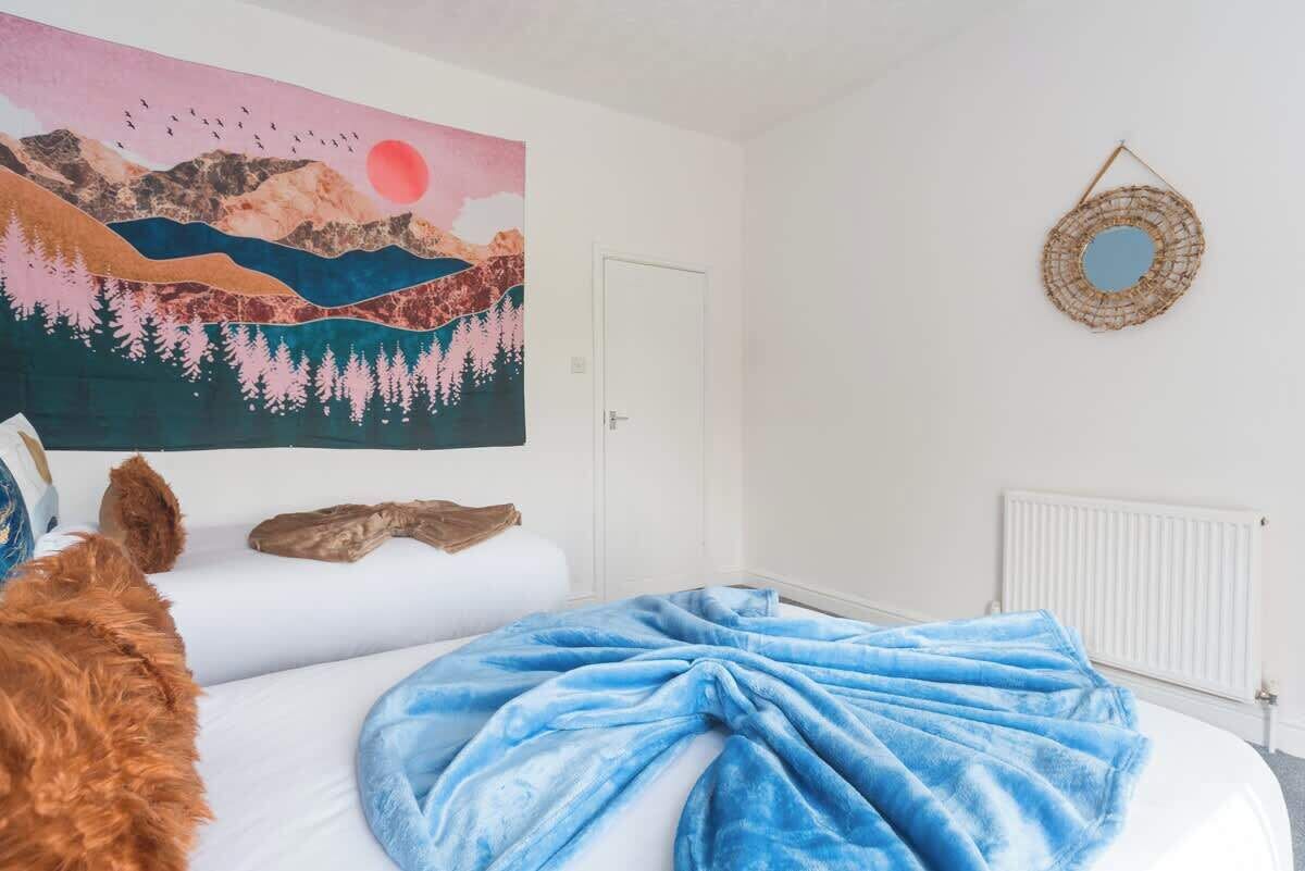 Ein Schlafzimmer mit einem Bett, einem großen Gemälde, einem Spiegel und einer Heizung.