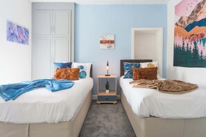 A bedroom with two beds, a nightstand, a wall-mounted shelf, and a door. - 3 Bed Adom Home - Walk to MKM Stadium (Kingston upon Hull)