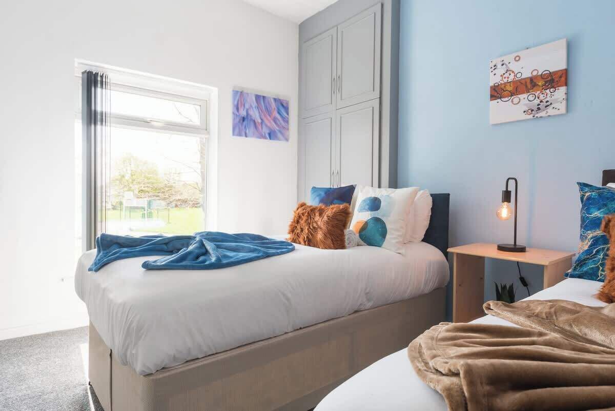 Ein Schlafzimmer mit einem Bett, einem Nachttisch, einer Lampe und Bildern an den Wänden.