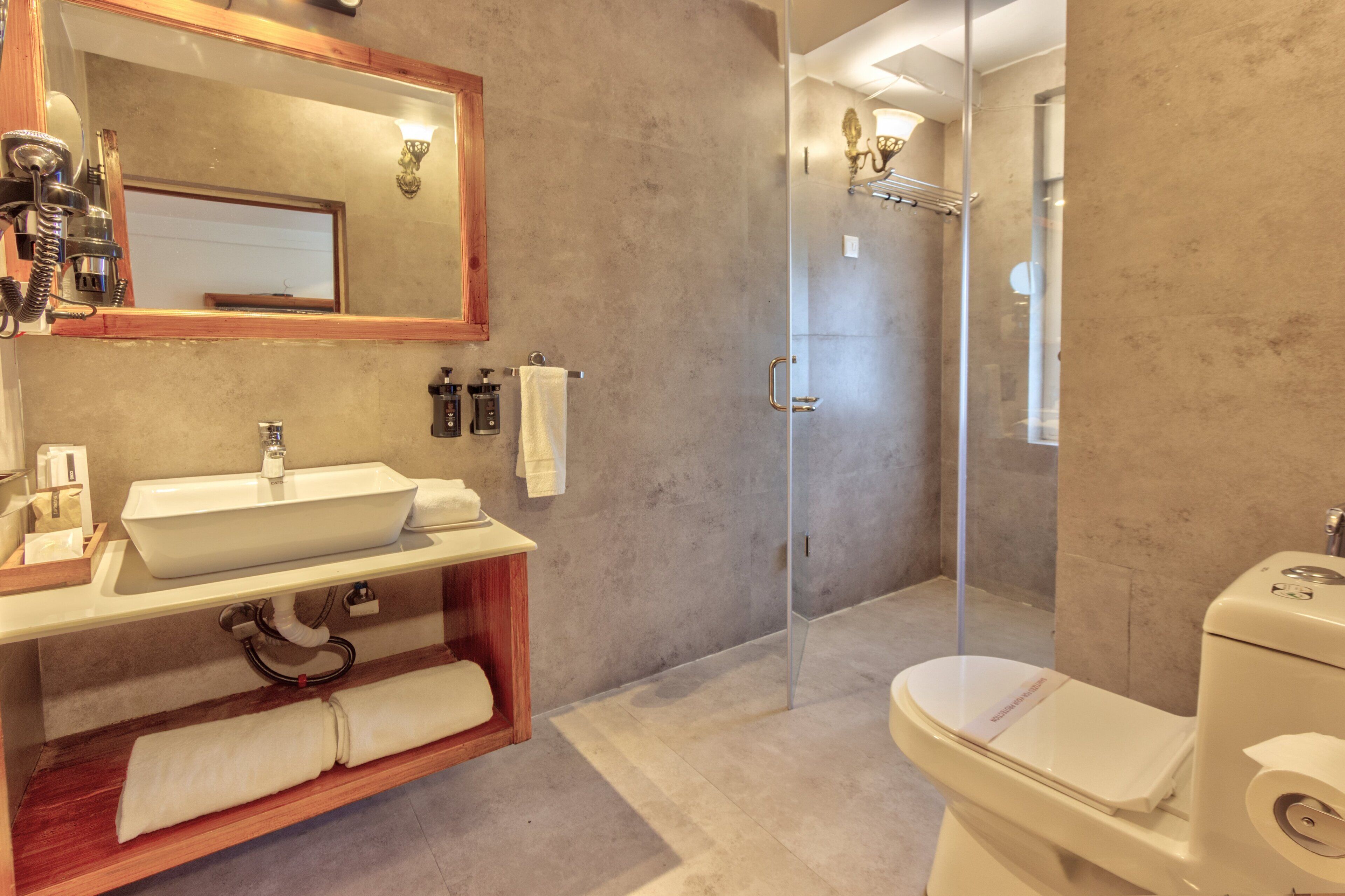 Un baño moderno con un lavamanos grande, cabina de ducha de vidrio y un inodoro.
