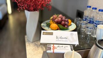 A welcome sign with a guest's name, a thank you note, and a fruit plate.
