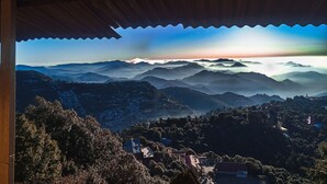 Une vue depuis un espace abrité, donnant sur un paysage montagneux sous un ciel dégagé.