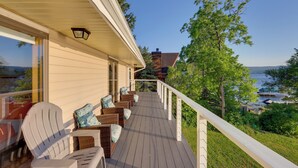A wooden deck with outdoor seating, a railing, and a view of the water. - Honeoye Lake House w/ Community Amenities! (Honeoye)