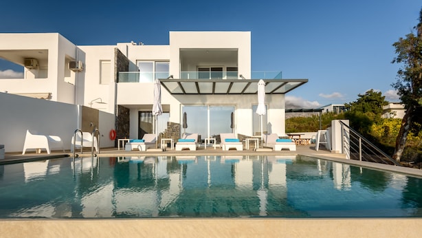 A modern hotel with a pool, outdoor seating, and a clear view of the surrounding landscape. - Villa Pelagia - Sea Front Villa Pelagia (Sfakia)