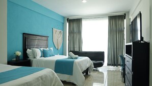 Habitación de hotel con dos camas, televisor, escritorio y silla.