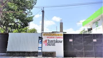 A gated area with a sign for "Tamtokow Hotel" and a parking sign.