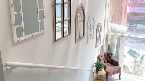 Una escalera con paredes blancas y ventanas decorativas.