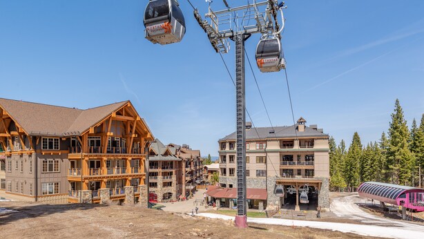 Une station de ski dotée d’un téléphérique, de bâtiments en bois et d’un télésiège.