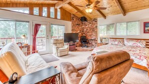 A spacious room with a large bed, a leather sofa, a desk with a clock, and a TV. - A Bed of Roses (Oakhurst)