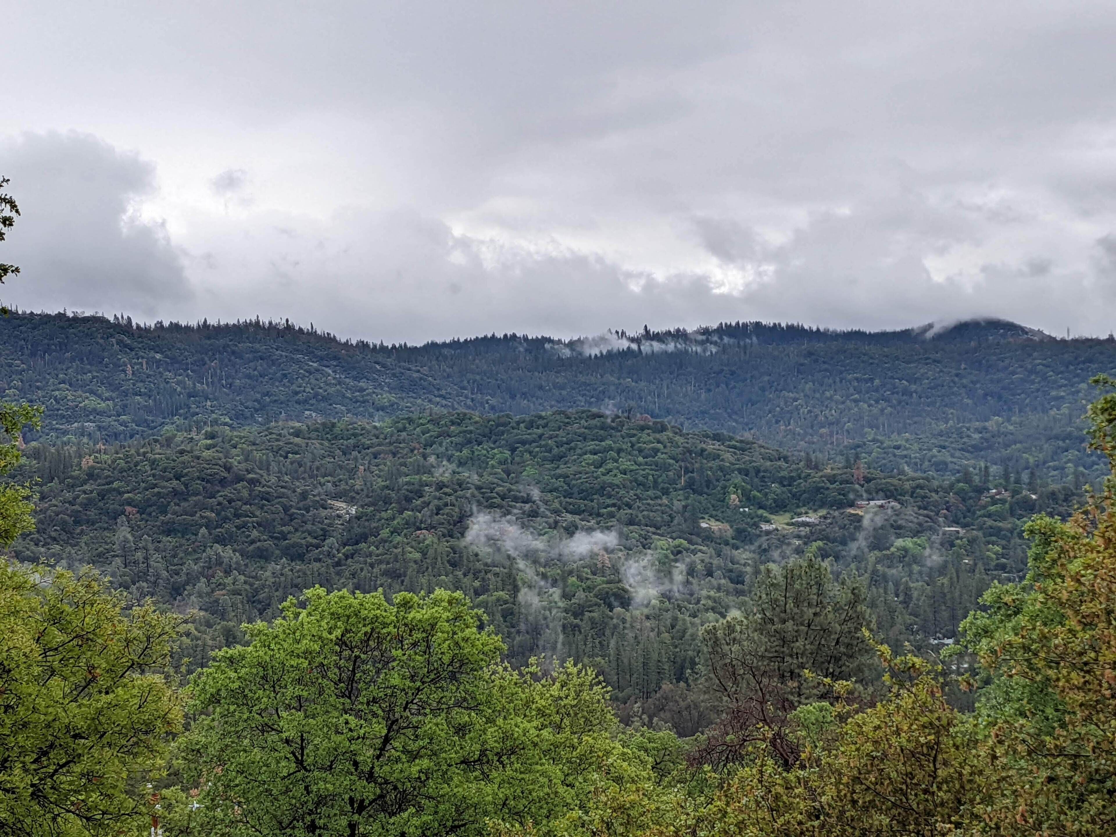 Paisagem montanhosa com florestas densas e um vale.