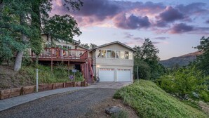 A two-story house with a balcony and a garage. - A Bed of Roses (Oakhurst)