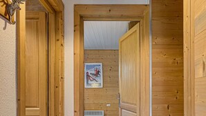 A wooden hallway with a ceiling light fixture and a poster on the wall. - Apartment Cry - Alpes Agency - Central Chamonix - Sleeps 2-4 (Chamonix-Mont-Blanc)