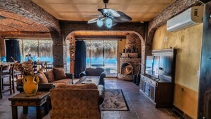A spacious living area with a fireplace, comfortable seating, and a television. - La Rosa del Encanto Beachfront Ground Floor West (Playa Encanto)