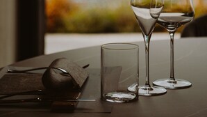 A table with two wine glasses and a small glass, a napkin, and a pair of scissors. - Ah Porticcioli boutique apartments (San Felice del Benaco)