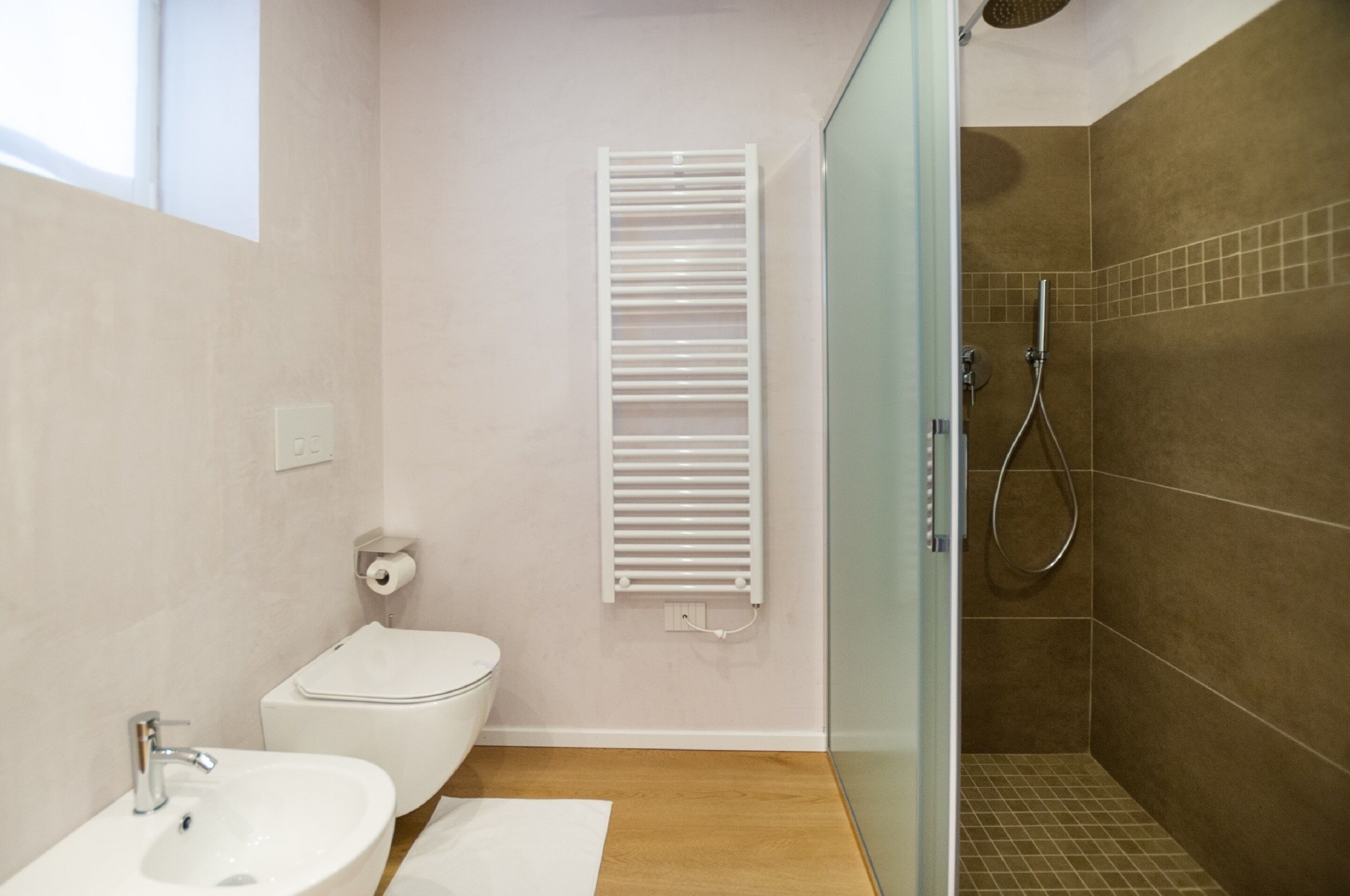 Une salle de bain moderne équipée de toilettes, d’un lavabo et d’une zone douche.