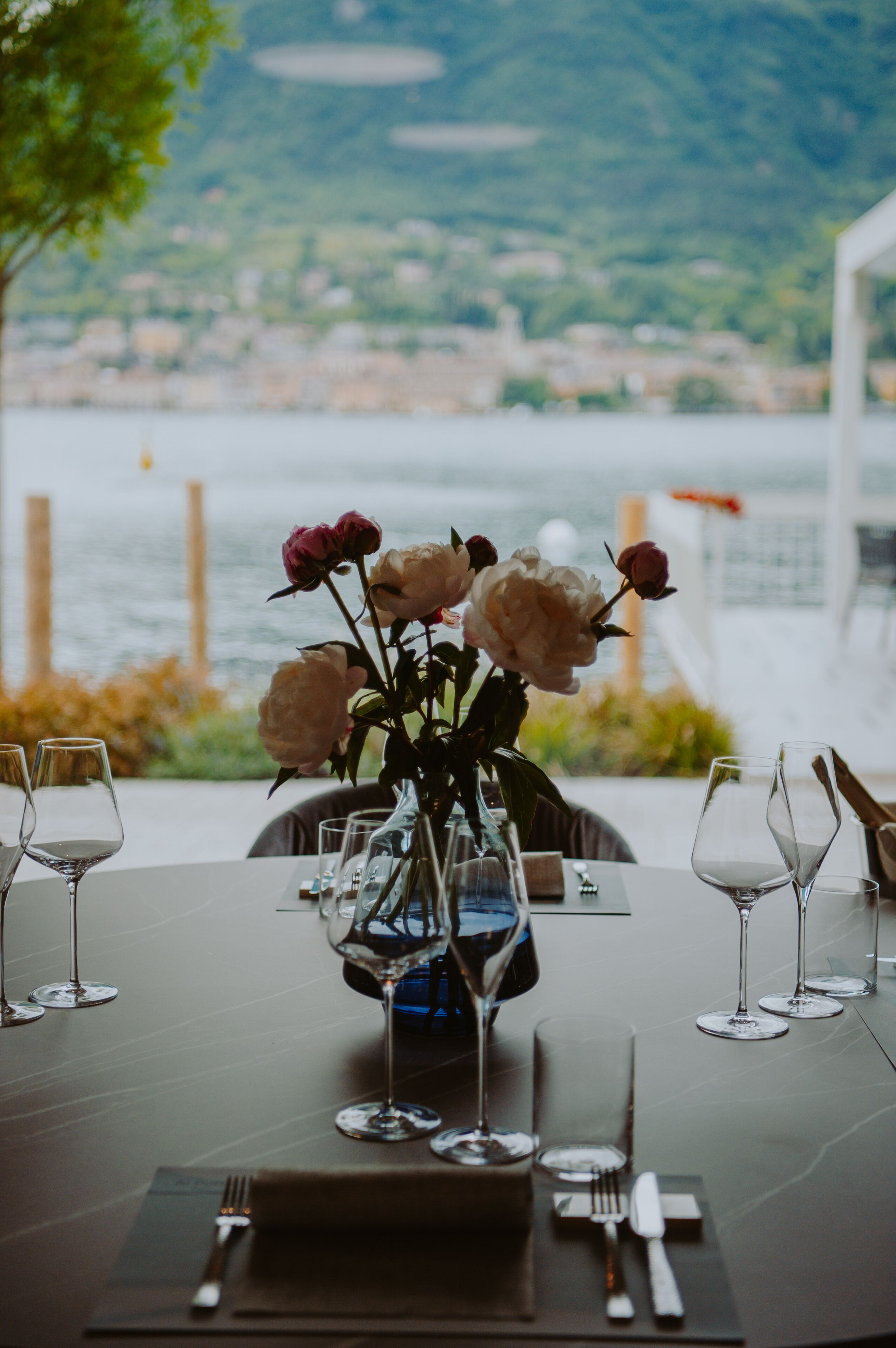 Een gedekte tafel met bloemen, glazen en bestek.