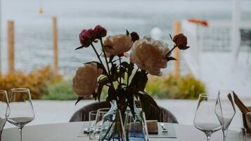 Een gedekte tafel met bloemen, glazen en bestek.