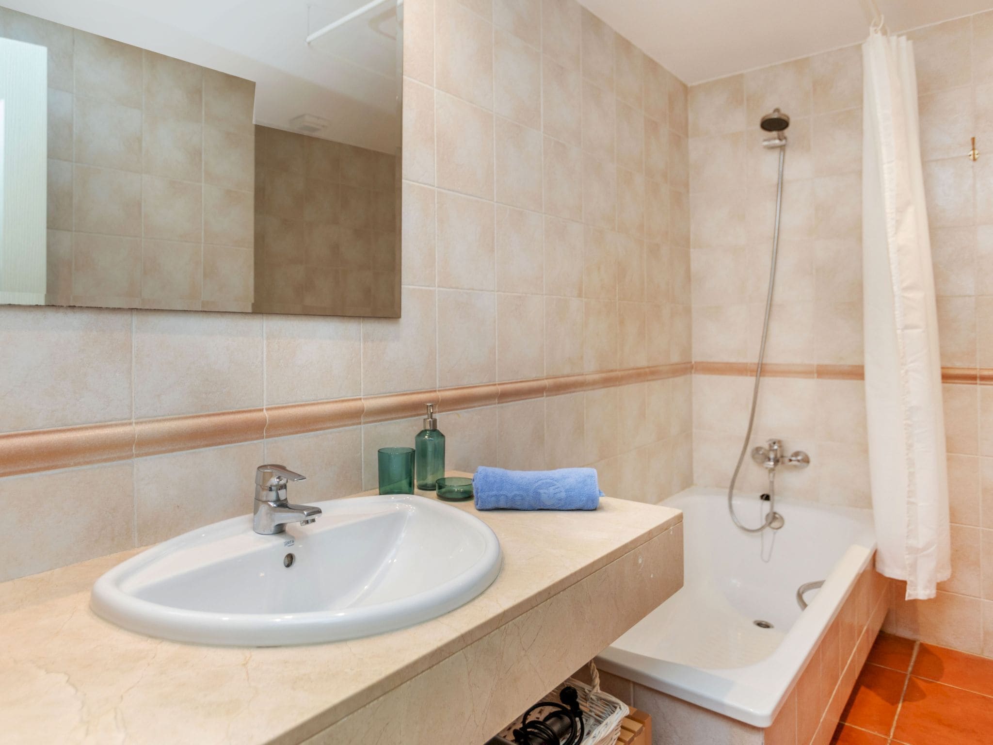 Une salle de bain équipée d’un lavabo, d’un miroir, d’une douche et d’une baignoire.
