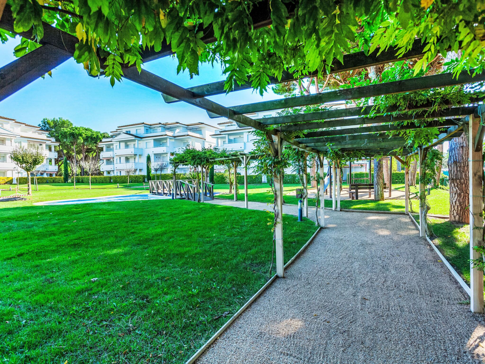 Un parc doté d’un sentier pédestre, d’une pelouse verdoyante et d’une structure en forme de pergola.