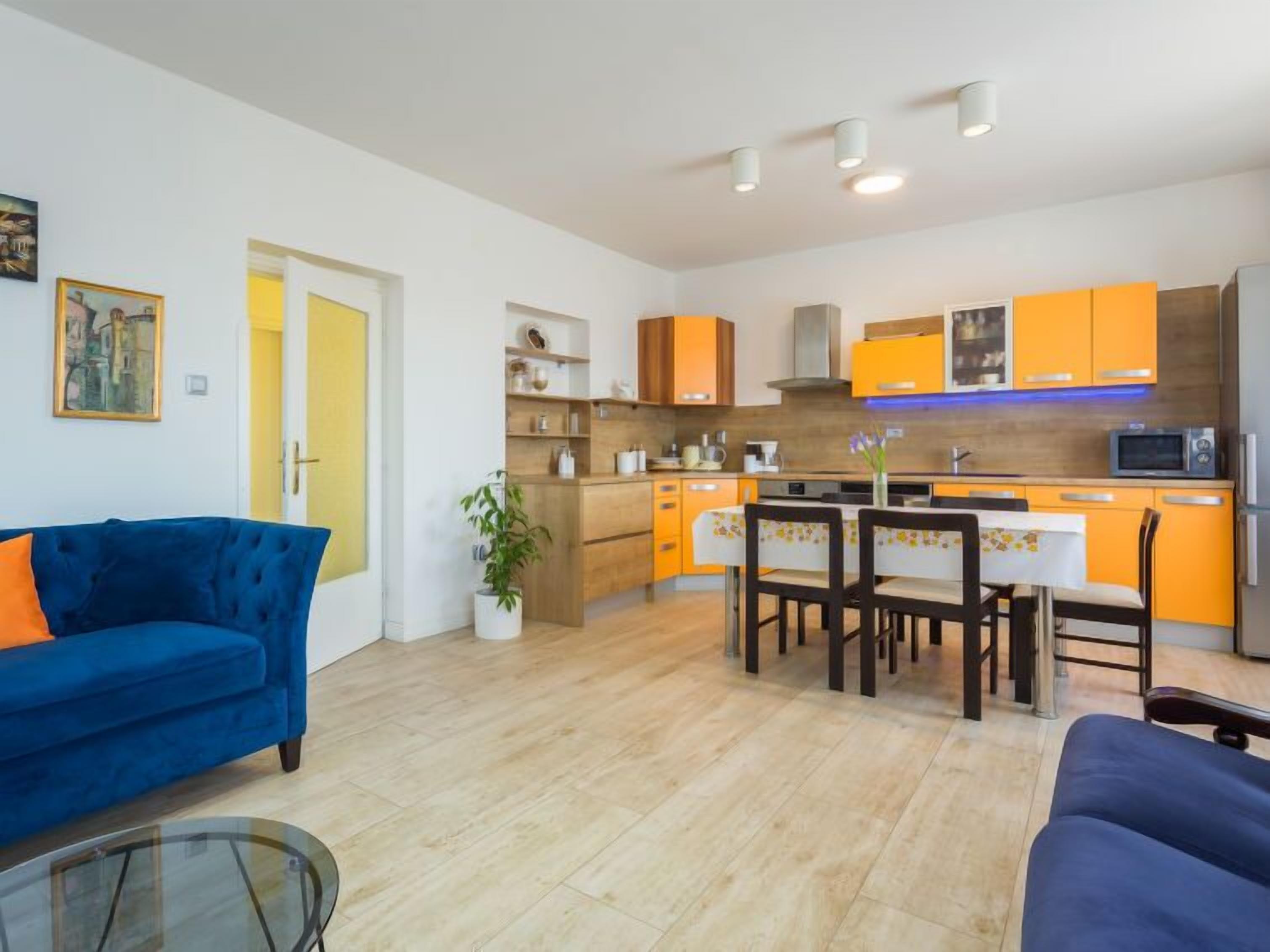 A modern apartment with a living room, dining area, and kitchen.