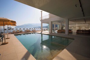 Una piscina al aire libre de temporada, sombrillas