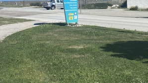 Ein Schild für Port Barcares mit mehrsprachiger Beschilderung und blauem Himmel.
