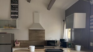 Eine Küche mit einer Steininsele, Barhocker, einer Mikrowelle und einem Kühlschrank.