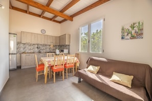 Un espacio habitable compacto con cocina, comedor y sofá.