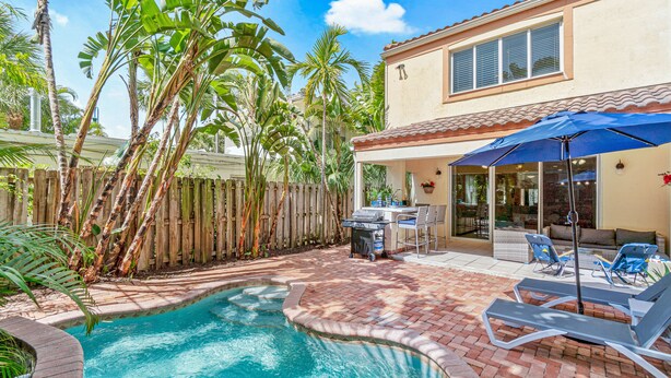 Un jardin avec une piscine, du mobilier de jardin et une clôture en bois.