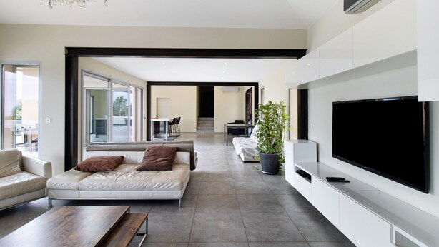 A modern living room with a large flat-screen TV, a sofa, a coffee table, and a potted plant. - Villa 'Gecko' with Sea View, Wi-Fi and Air Conditioning (SARI SOLENZARA)