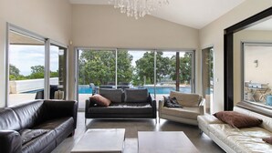 A spacious living area with a pool view, a chandelier, and a modern interior design. - Villa 'Gecko' with Sea View, Wi-Fi and Air Conditioning (SARI SOLENZARA)