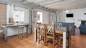 Un comedor con mesa y sillas de madera, una encimera de cocina y un sofá azul.