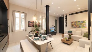 A modern living room with a sofa, a coffee table, and a dining area with a bench and table set. - Located in the Heart of Heraklion, combining Elegance & Modern Luxury.  (Iraklio)