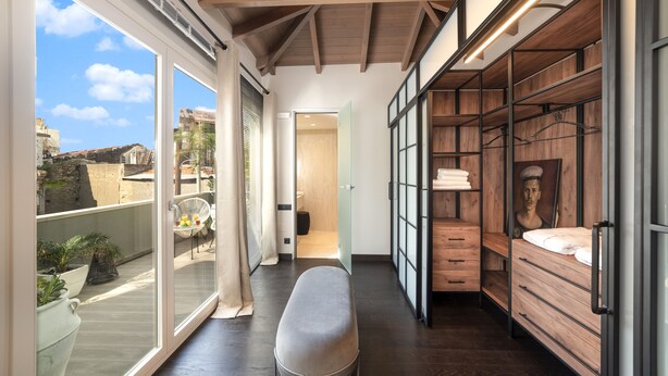 A modern interior with a bench, wooden furniture, and large windows offering a view of the outside. - Located in the Heart of Heraklion, combining Elegance & Modern Luxury.  (Iraklio)