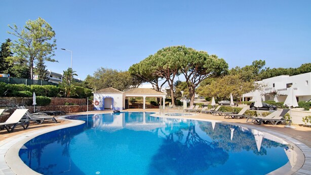 A circular swimming pool with lounge chairs and a gazebo. - Balaia Apartment near the Beach with Shared Pools (Albufeira)