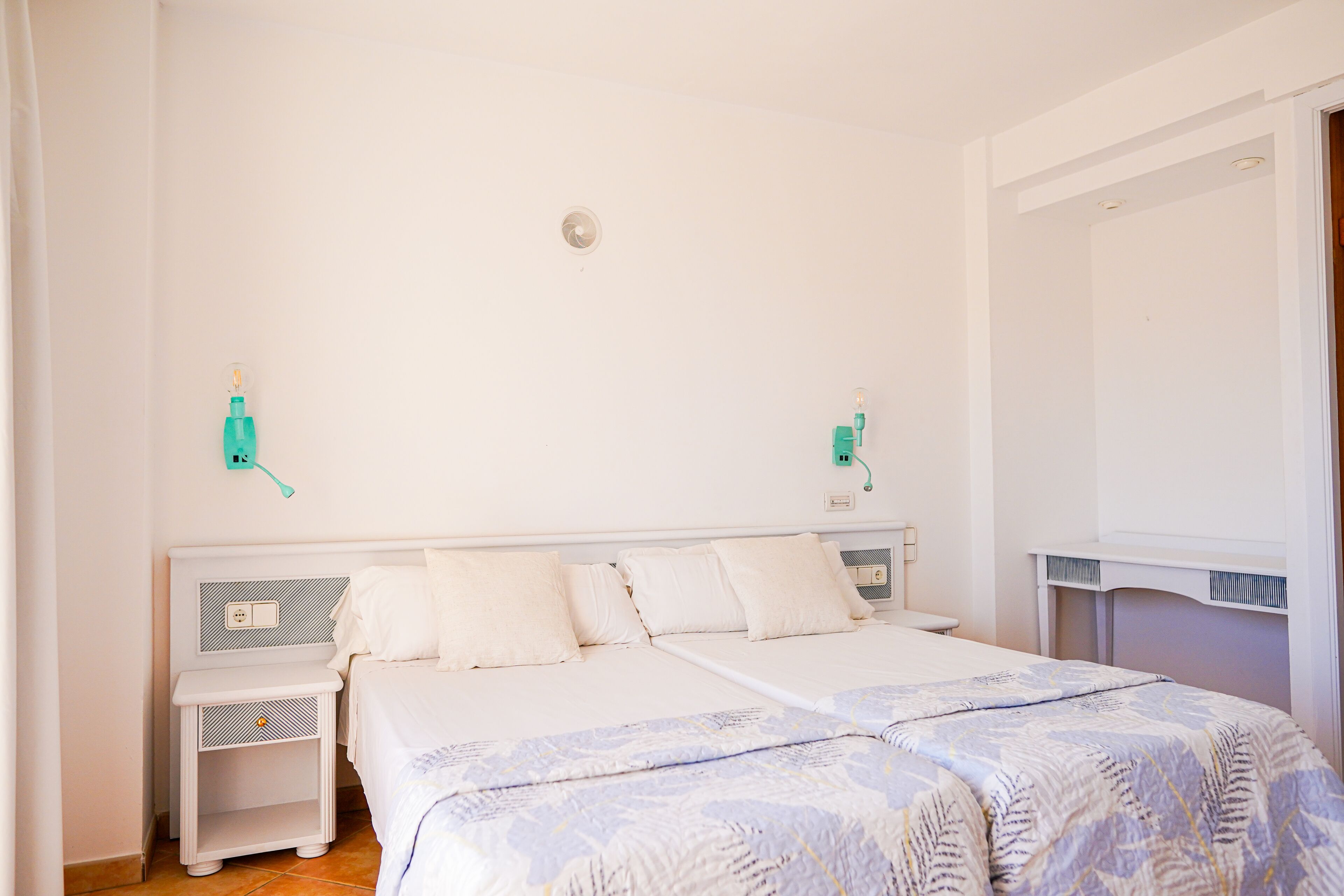 A bedroom with a large bed, two bedside tables, and a nightstand.