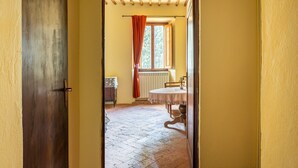 Uma porta que dá para um quarto com uma mesa e uma janela.