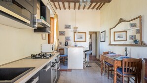 Uma cozinha com ilha central, mesa de jantar com cadeiras e um espaço bar.