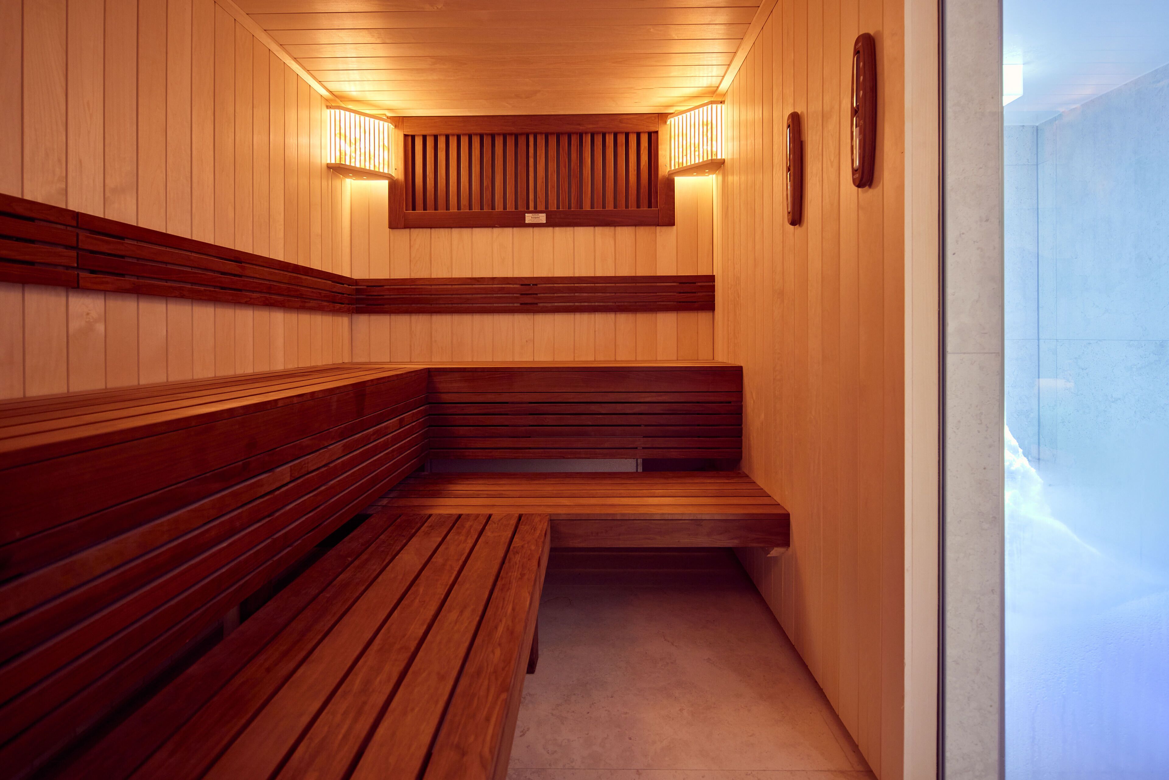 Una sauna con bancos de madera y techo inclinado.