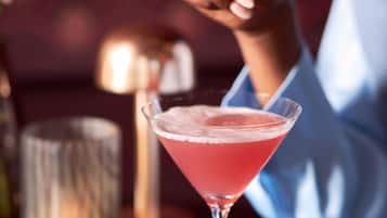 Ein Cocktail in einem Martiniglas auf einem Tisch, unscharfer Hintergrund.