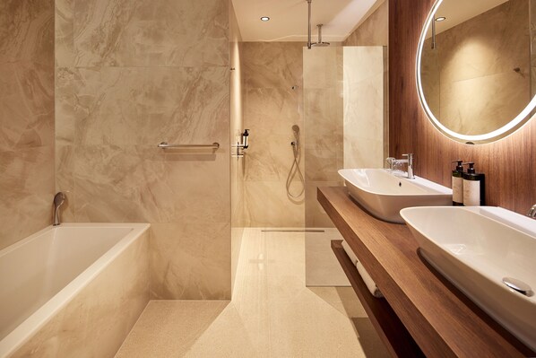 Un baño moderno con cabina de ducha, dos lavabos y un espejo grande.