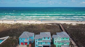 Una propiedad costera con vista a la playa, un muelle y una serie de casas azules.