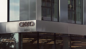 A modern hotel building with a prominent 'OKKHO' sign, large windows, and a reflective glass facade. - OKKO Hotels Paris la Défense (Nanterre)