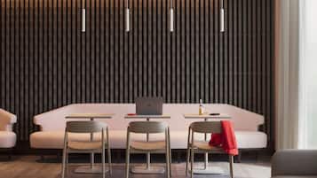 Un intérieur moderne avec un canapé, deux fauteuils, une table et un ordinateur portable.