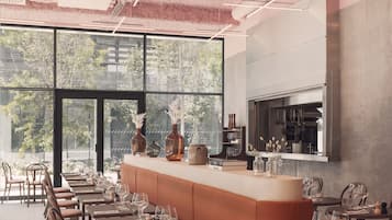 Un restaurant moderne doté d’un long comptoir, de nombreuses tables et de chaises.