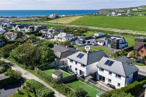 A residential area with houses, a road, and a view of the sea.