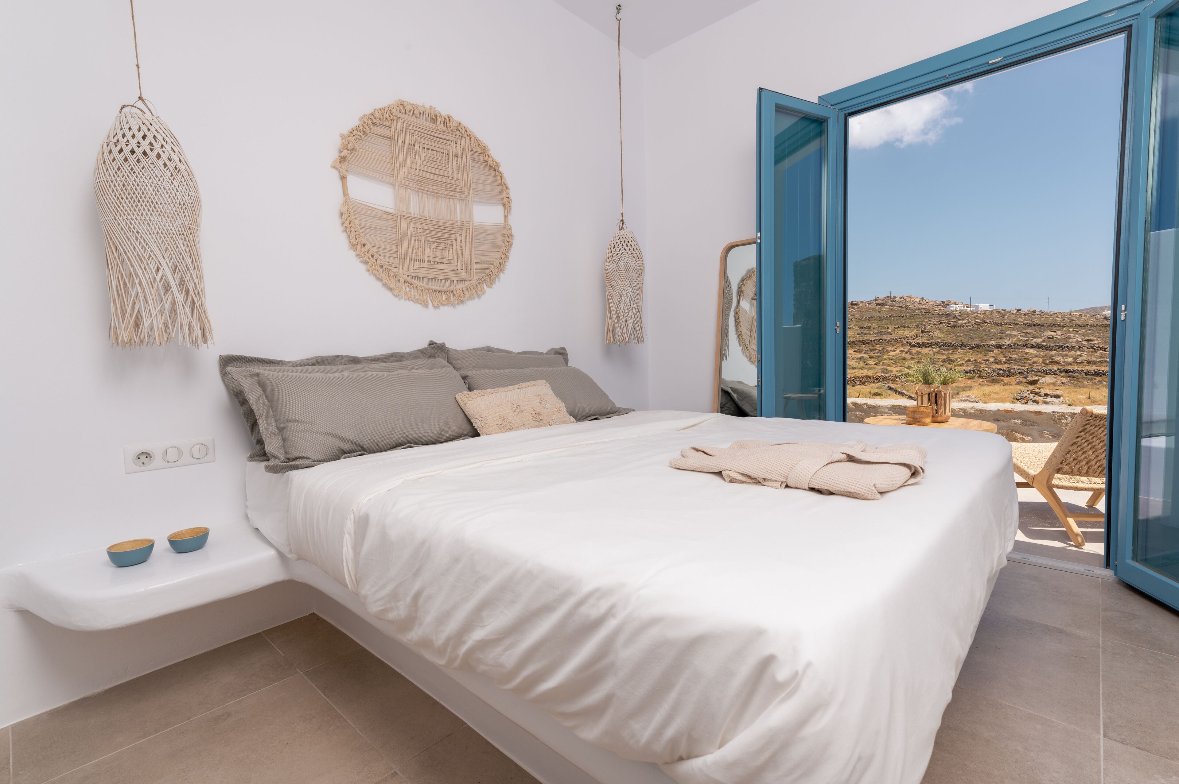Un dormitorio con cama, mesitas de noche y vistas al exterior.