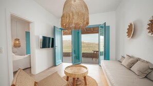 Une pièce moderne avec un canapé, une table ronde en bois et un téléviseur.