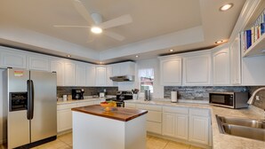 A modern kitchen with white cabinetry, a central island, stainless steel appliances, and a built-in microwave. - Chic Port Angeles Home w/ Oceanfront Balcony! (Port Angeles)
