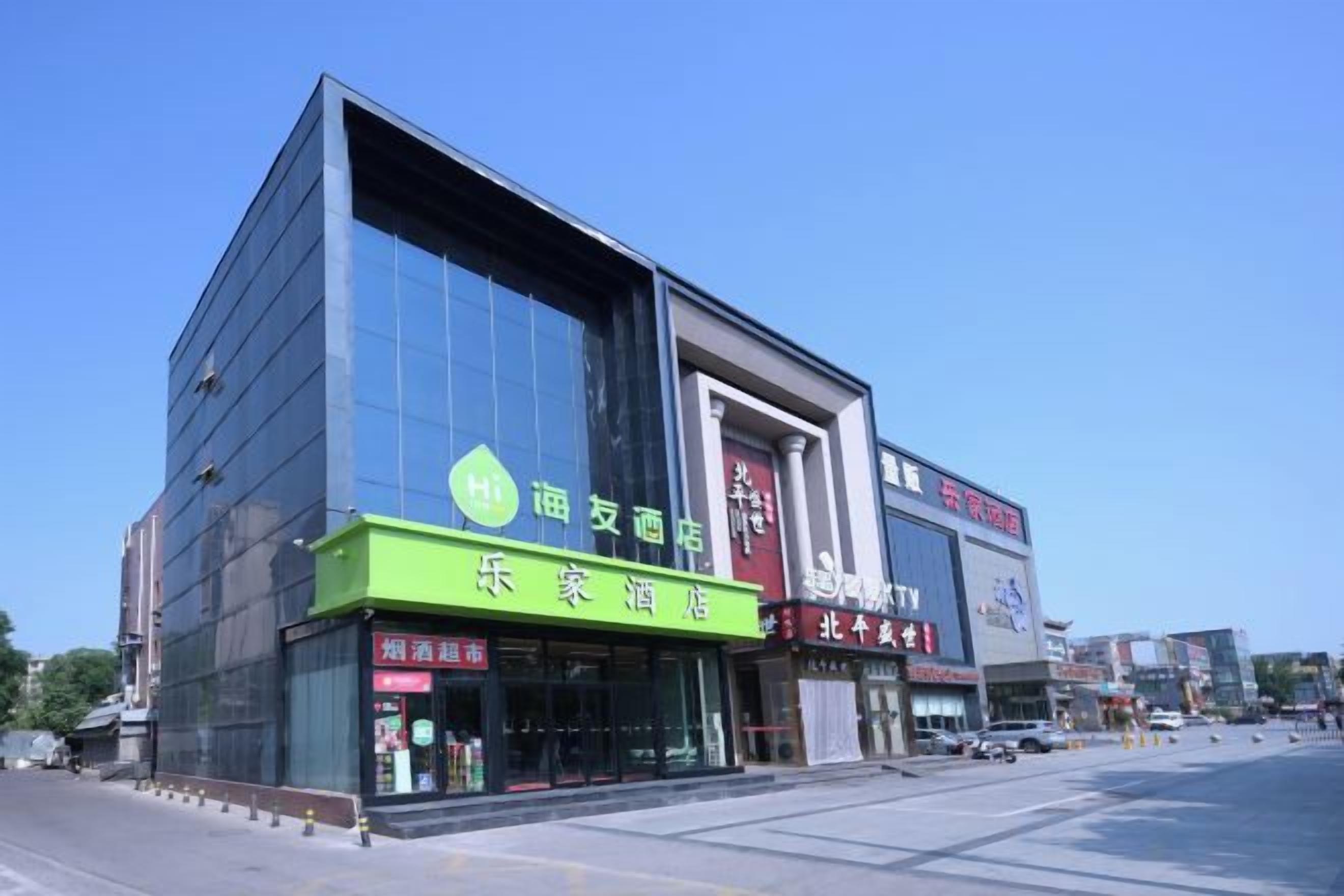 A modern building with a green storefront and a large glass facade.